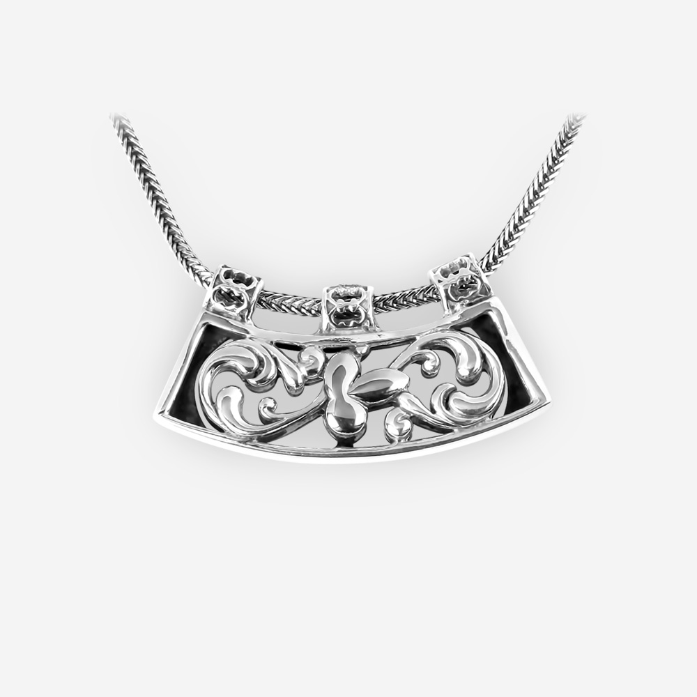 Floral filigree silver necklace with a sculpted leaf pendant on a silver chain.